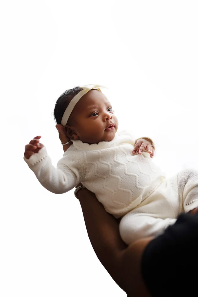Baby looking up while being held in a parent's arms