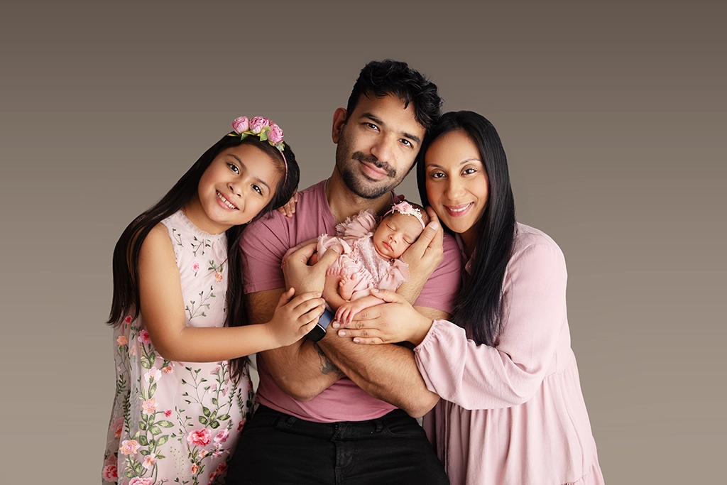 Family wearing coordinated pink outfits during a newborn family photography session in Enfield, North London