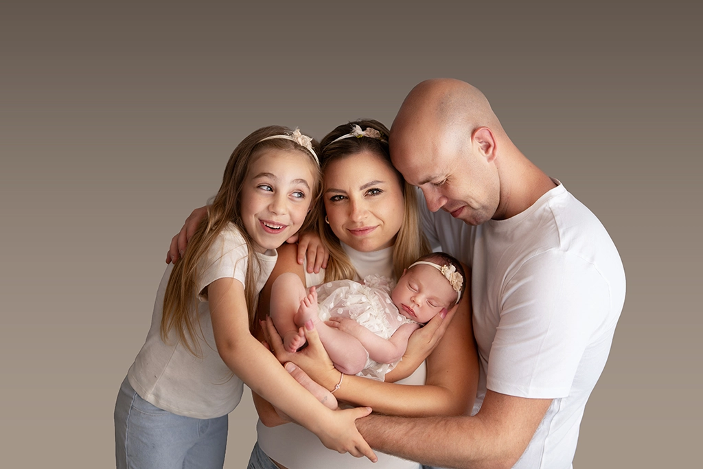 Parents and older sister holding their newborn baby during a family photography session in Enfield, North London