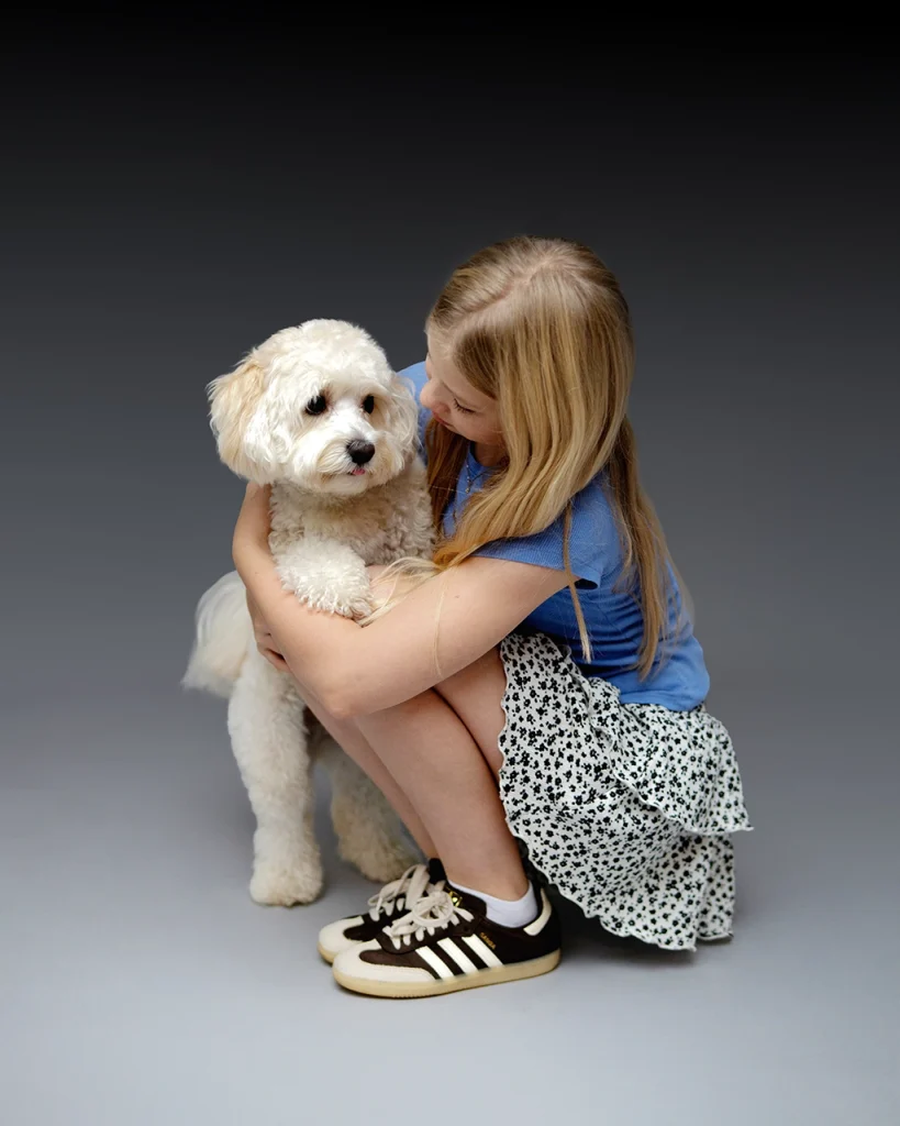 Girl cuddling her family dog during a family photography session with pets in Enfield, North London