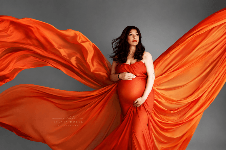 Maternity photography in Enfield, North London – pregnant woman in an orange flowing dress