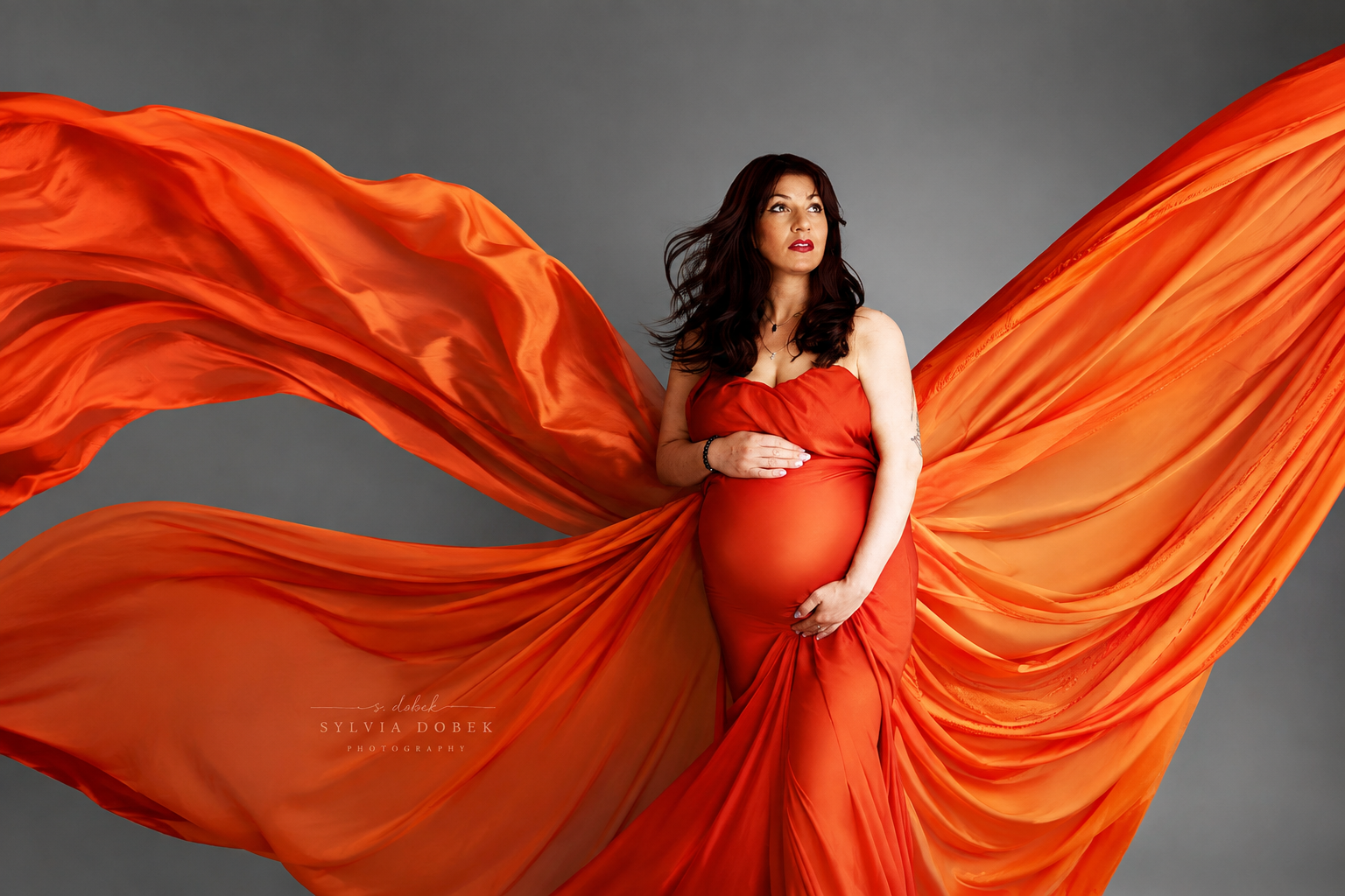Maternity photography in Enfield, North London – pregnant woman in an orange flowing dress