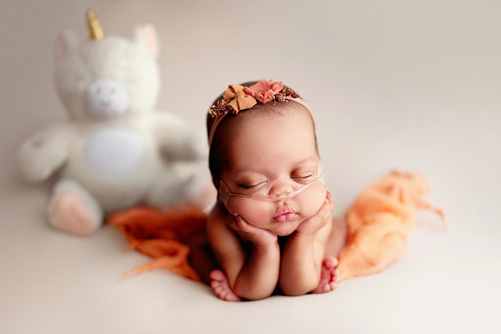 Sleeping newborn baby photographed with a special unicorn toy in Enfield, North London