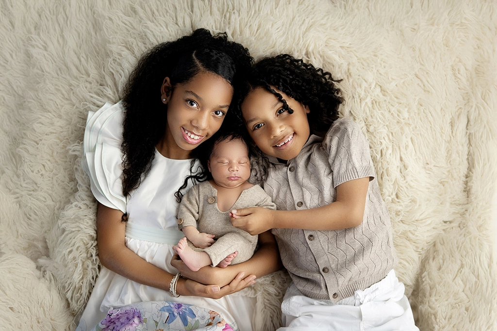 Newborn baby photographed with older siblings during a newborn photography session in Enfield, North London