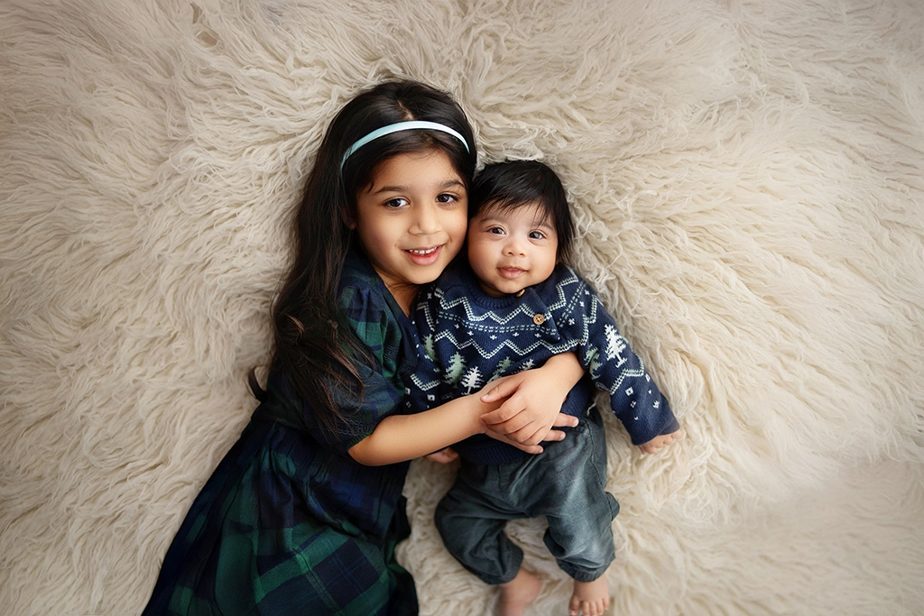 Newborn baby with older sister during a sibling portrait in Enfield, North London
