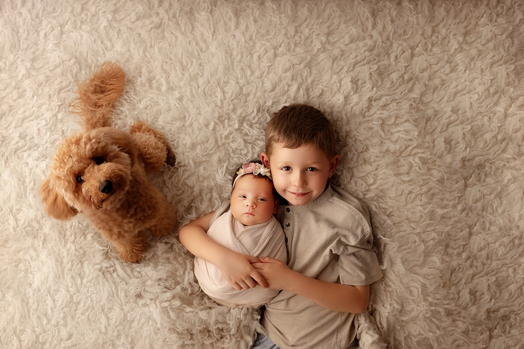 Newborn baby photographed with older sibling and family dog during a newborn photography session in Enfield, North London