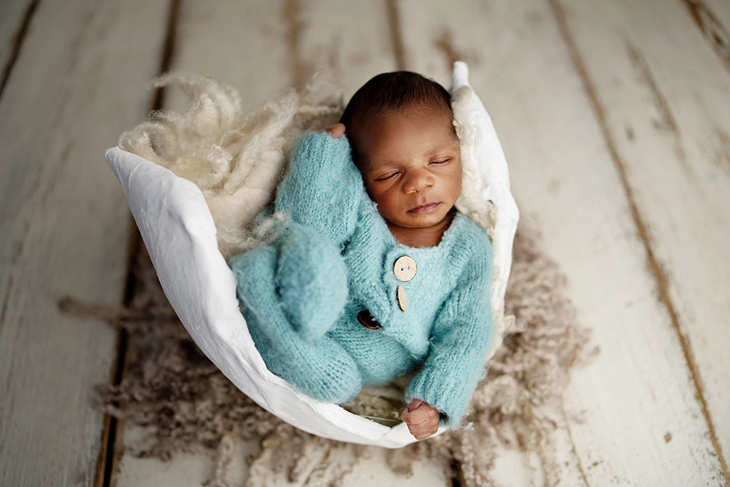Newborn baby safely posed inside a pregnancy belly cast during a creative newborn photography session