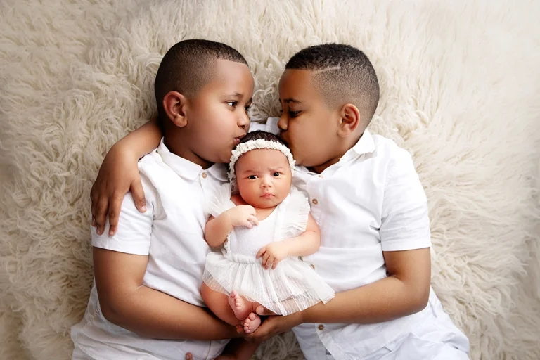 Siblings wearing coordinated white outfits during a newborn family photography session in Enfield, North London