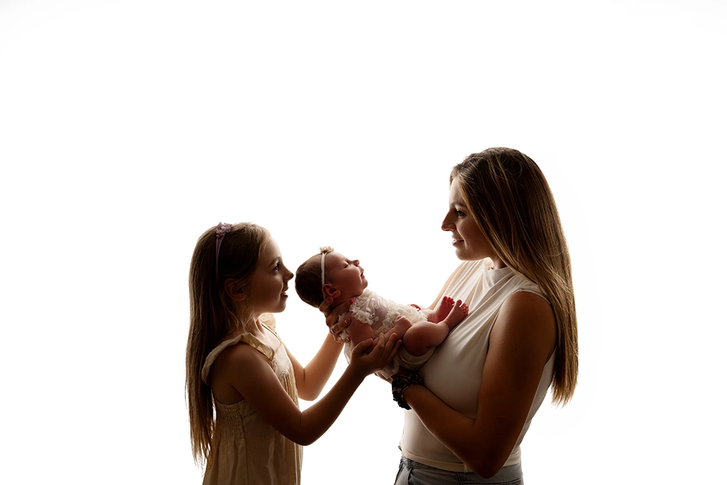 Mum with her baby and older daughter during a family photography session in Enfield, North London