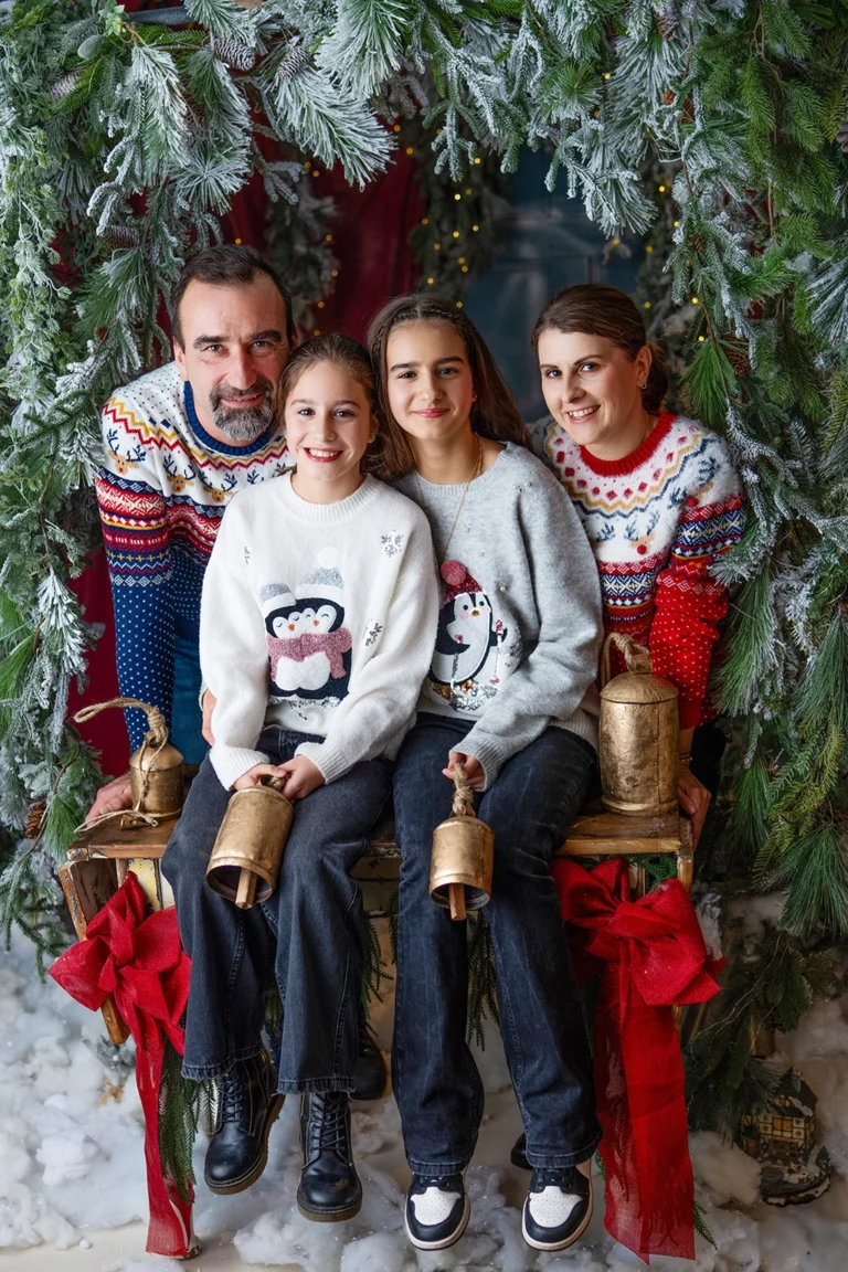 Family with two daughters wearing festive Christmas jumpers during a photography session in Enfield, North London