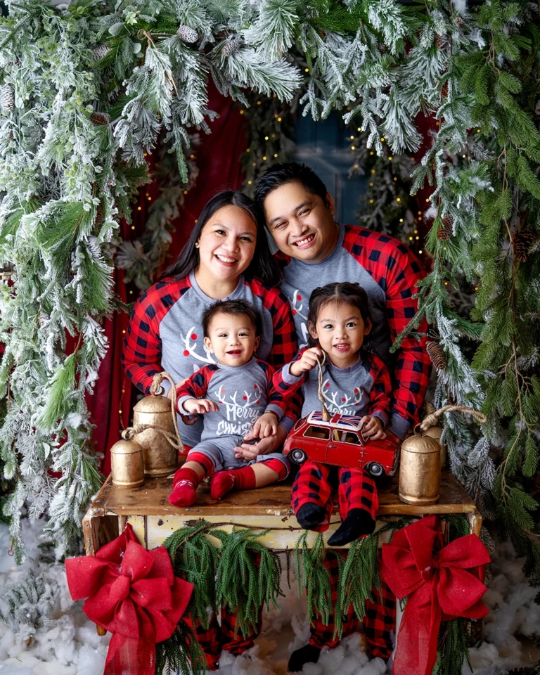 Family with two young children wearing matching Christmas pyjamas during a festive photography session in Enfield, North London