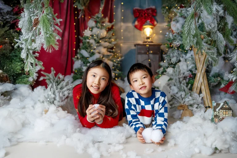 Brother and sister playing with snowballs during a Christmas photography session in Enfield, North London