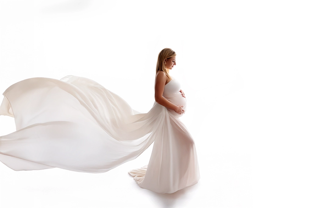 Pregnant woman in a flowing white dress during a maternity photography session in Enfield, North London