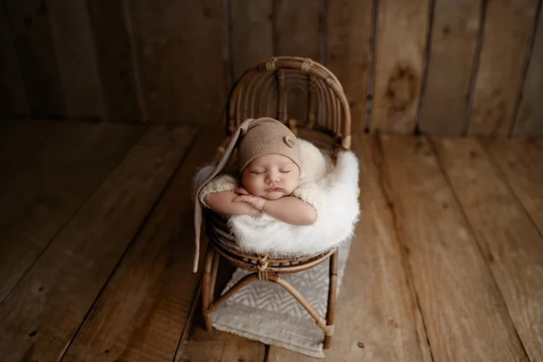 Newborn baby sleeping in a wooden prop during a newborn photography session in Enfield, North London