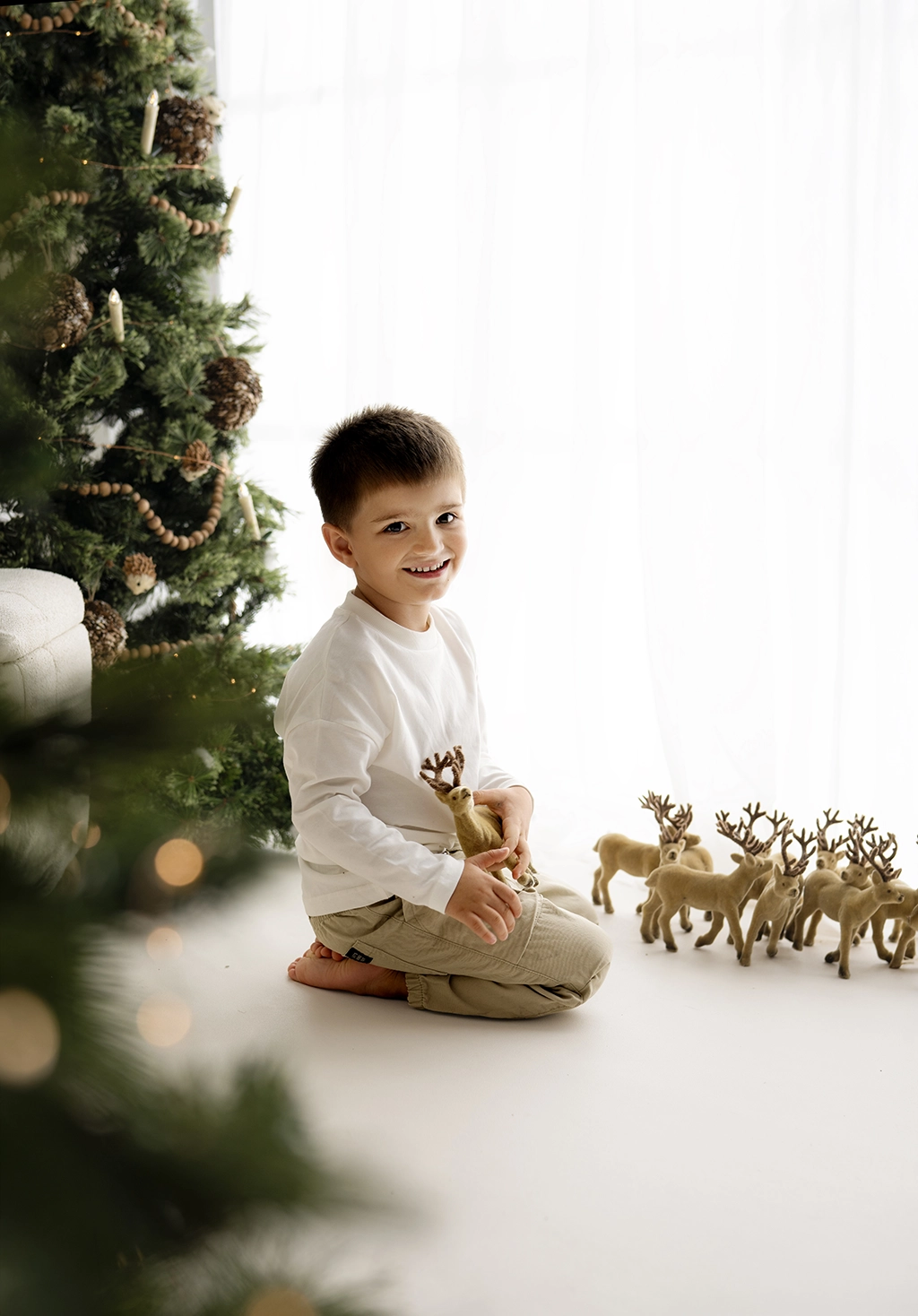 Young boy beside the Christmas tree in the Enfield studio