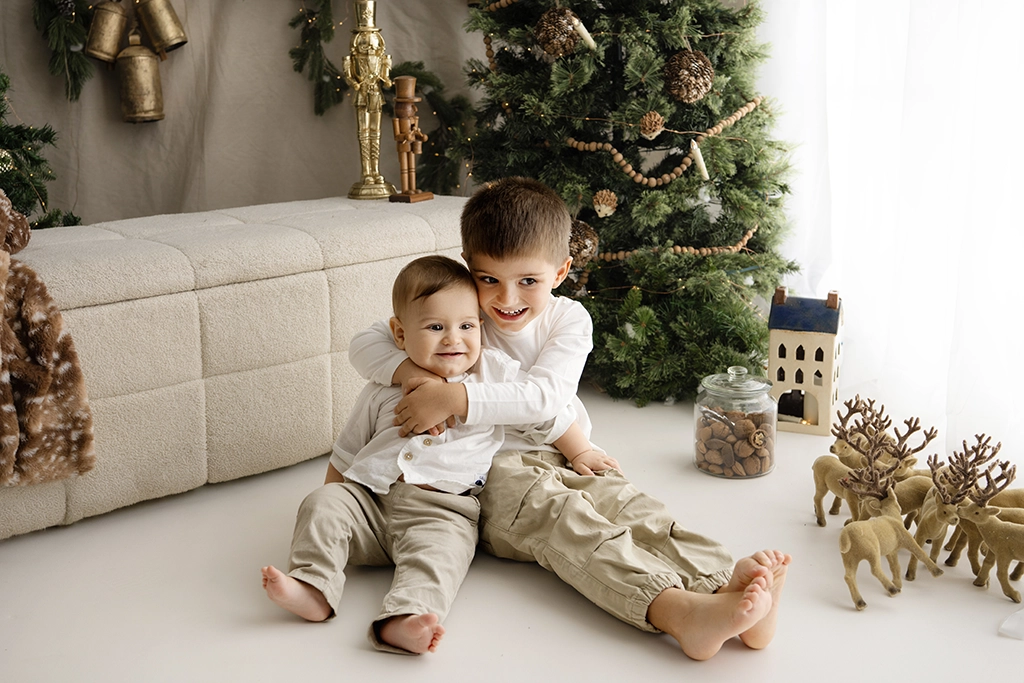 Two brothers cuddling in the cream Christmas setting